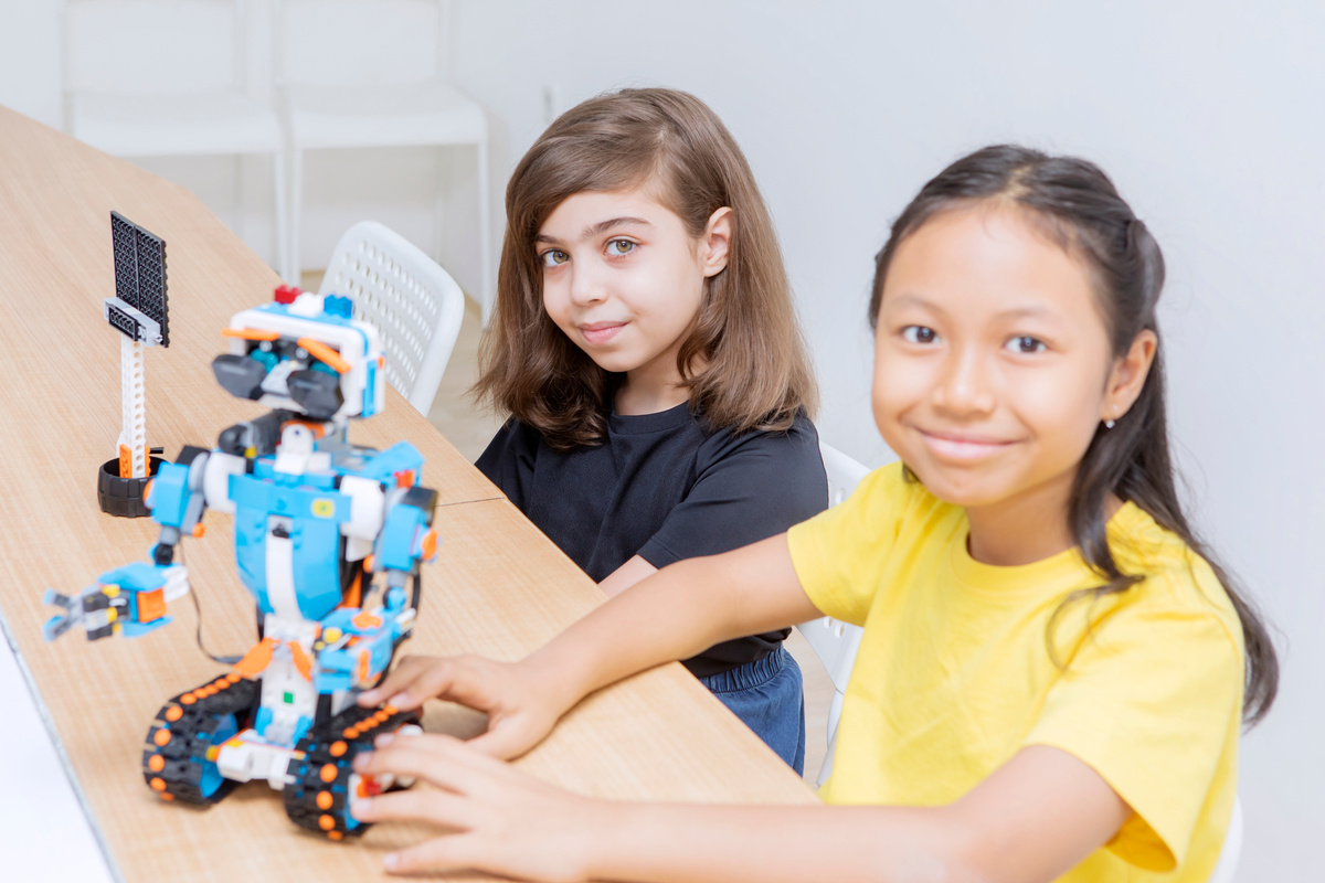 Two Cute Girls Constructing a Lego Robot in Class